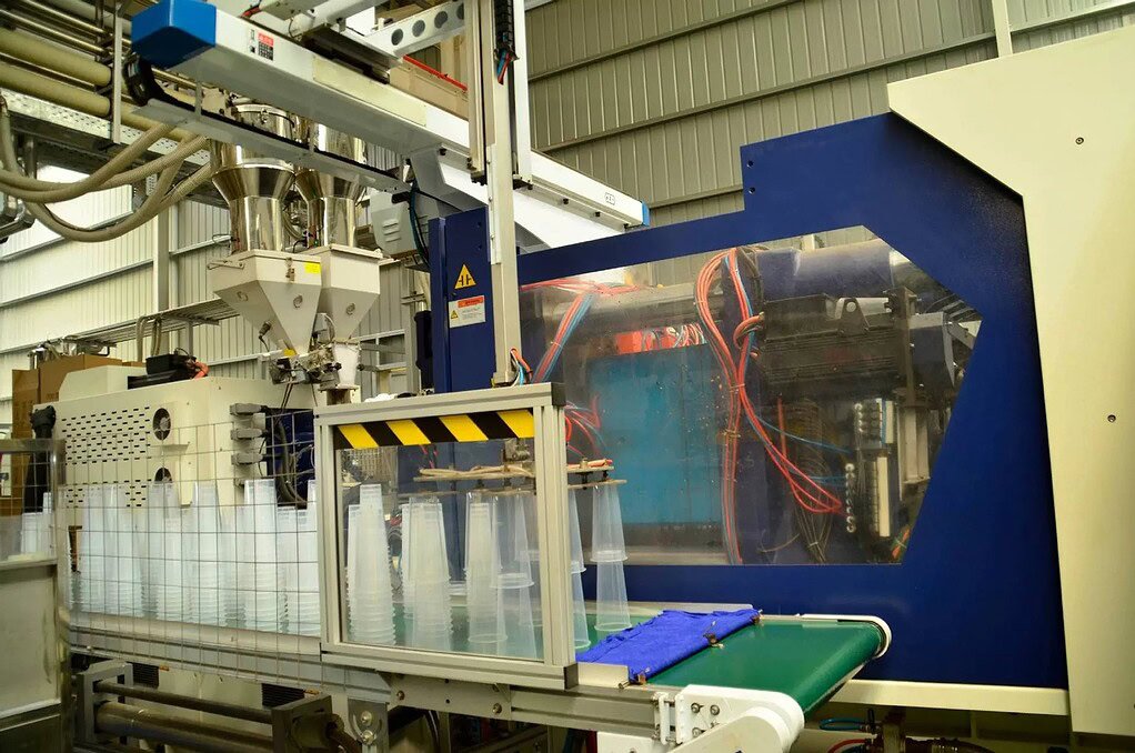 Industrial machine for manufacturing glass and plastic bottles in a factory setting.