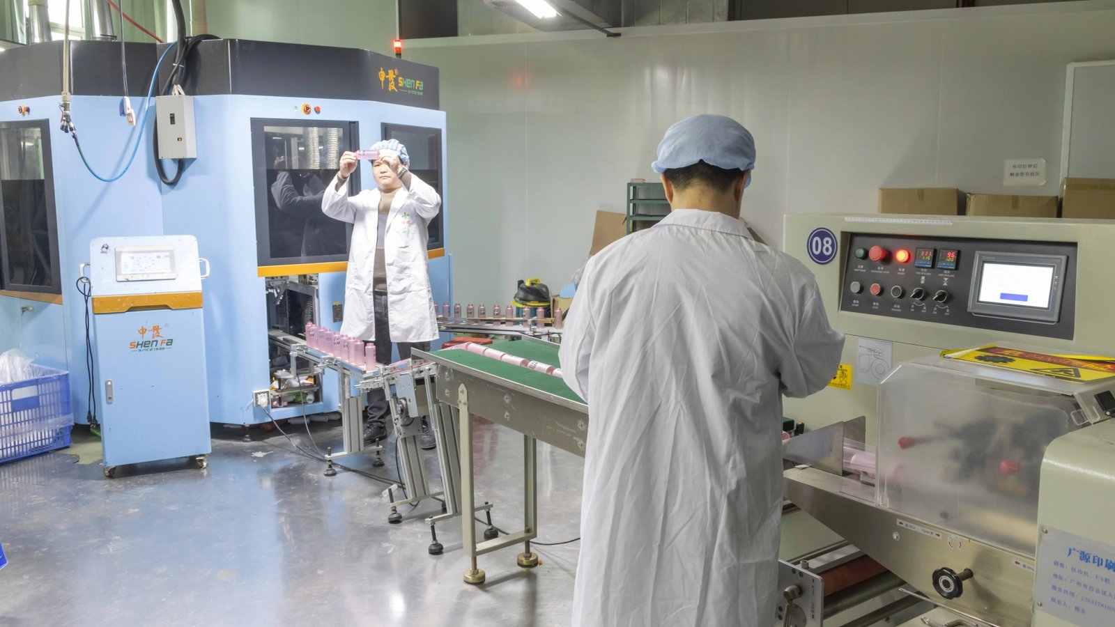 Manufacturing workers inspecting plastic bottles in a factory production line.