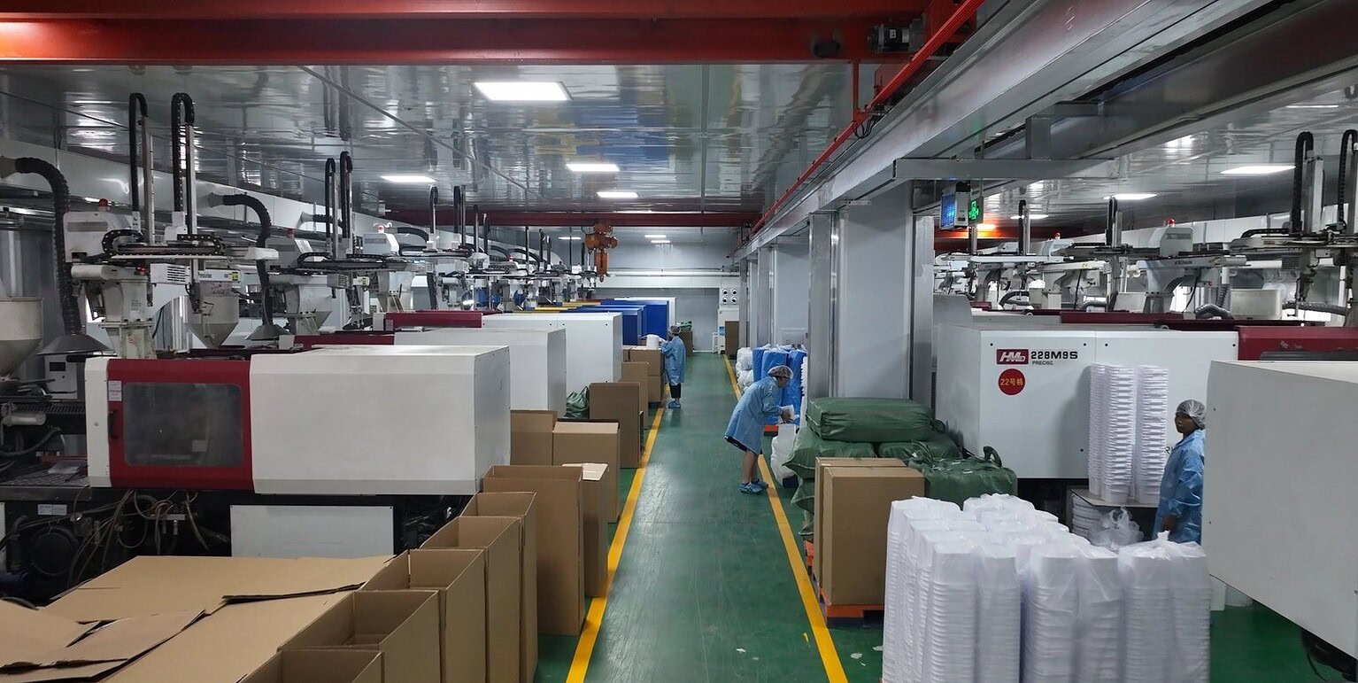High-volume production of glass and plastic bottles in a modern factory setting.